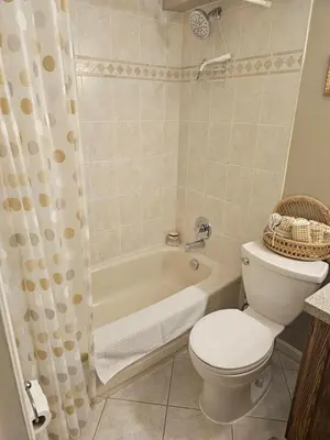 a bathroom with a toilet and a tub and a sink at Window Hill in St. Albert
