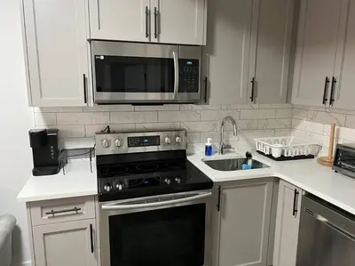 a kitchen with a stove and a microwave at Modern Luxury Private Suite in Airdrie