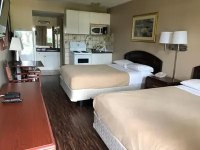 a hotel room with two beds and a kitchen at Travellers Inn in Calgary
