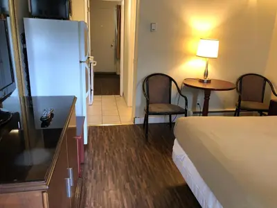 a hotel room with a bed and a table and chairs at Travellers Inn in Calgary