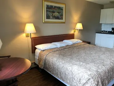a hotel room with a bed and a table at Travellers Inn in Calgary