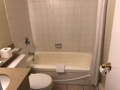 a bathroom with a white tub and a toilet at Travellers Inn in Calgary