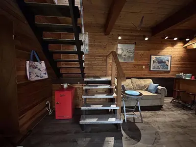 a living room with a staircase and a couch at Charming Hidden Gem- Ocean View and Marina in Campbell River