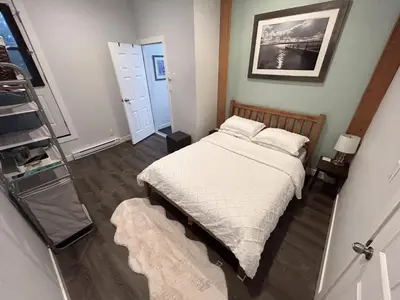 a small bedroom with a bed and a ladder at Charming Hidden Gem- Ocean View and Marina in Campbell River