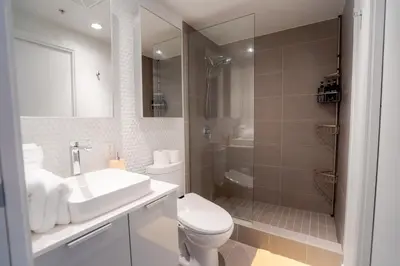 a bathroom with a toilet and a sink and a shower at High rise Apartment in Vancouver