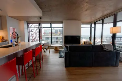 a living room with a black couch and red chairs at High rise Apartment in Vancouver