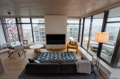 a living room with a couch and large windows at High rise Apartment in Vancouver