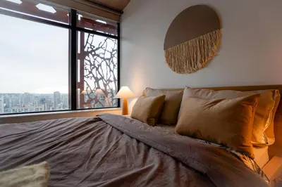 a bedroom with a large bed with a large window at High rise Apartment in Vancouver