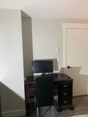 an office with a desk with a monitor and a chair at Entire 2BR Guest House in Quiet Area in Nanaimo
