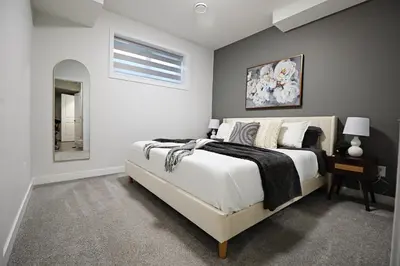 a bedroom with a large bed and a mirror at Beautiful Suite King Bed,Long Stays,Disney,Airport in Edmonton