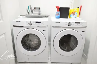 two washing machines and a sink in a laundry room at Beautiful Suite King Bed,Long Stays,Disney,Airport in Edmonton