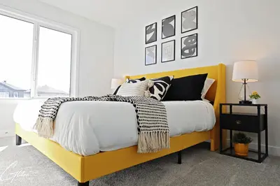 a bedroom with a yellow bed with black and white pillows at Beautiful Home With 4 King Beds,Airport,Disney+ in Edmonton
