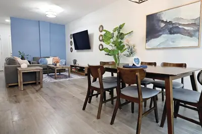 a living room with a table and chairs and a couch at Beautiful Home With 4 King Beds,Airport,Disney+ in Edmonton