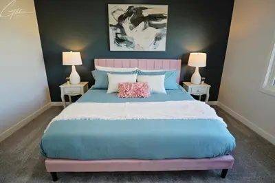 a bedroom with a bed with a pink headboard and two lamps at Beautiful Home With 4 King Beds,Airport,Disney+ in Edmonton