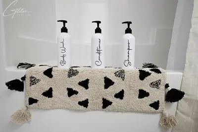 a towel holder with three bottles on top of a bath tub at Beautiful Home With 4 King Beds,Airport,Disney+ in Edmonton
