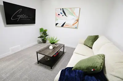 a living room with a couch and a table at Beautiful Home With 4 King Beds,Airport,Disney+ in Edmonton