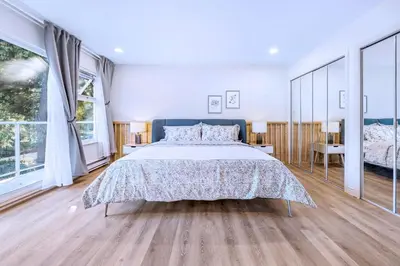 a large bedroom with a large bed and large windows at Three-Tree Villa-Central Location in Vancouver