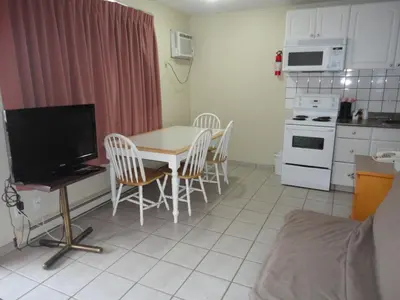 a kitchen with a table and chairs and a television at Canadas Best Value Inn & Suites-Vernon in Vernon