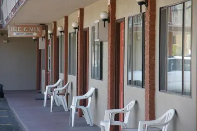 a row of white chairs sitting outside of a building at Canadas Best Value Inn & Suites-Vernon in Vernon