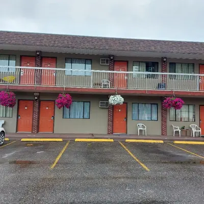 a parking lot in front of a building with red doors at Canadas Best Value Inn & Suites-Vernon in Vernon