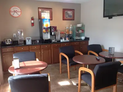 a restaurant with two tables and chairs and a counter at Canadas Best Value Inn & Suites-Vernon in Vernon