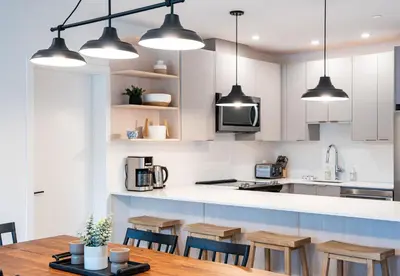 a kitchen with white cabinets and a wooden table at Farwell's Spike by Revelstoke Vacations in Revelstoke