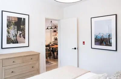a bedroom with a bed and a dresser with two pictures on the wall at Farwell's Spike by Revelstoke Vacations in Revelstoke