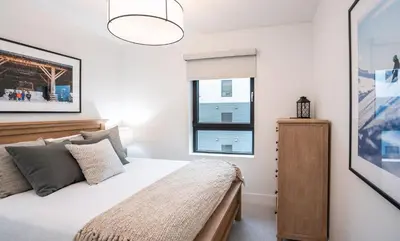 a bedroom with a bed and a window at Farwell's Spike by Revelstoke Vacations in Revelstoke