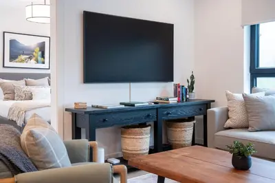 a living room with a table with a tv on a wall at Farwell's Spike by Revelstoke Vacations in Revelstoke
