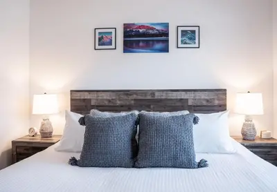 a bedroom with a bed with blue and white pillows at RevelStoked Getaway by Revelstoke Vacations in Revelstoke
