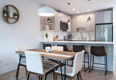 a kitchen and dining room with a wooden table and chairs at RevelStoked Getaway by Revelstoke Vacations in Revelstoke