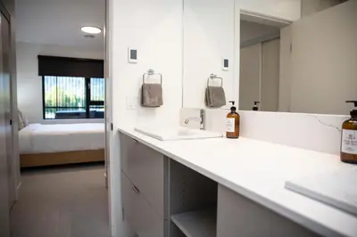a white bathroom with two sinks and a bed at Revy Mountain Retreat in Revelstoke