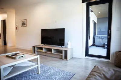 a living room with a flat screen tv and a table at Revy Mountain Retreat in Revelstoke