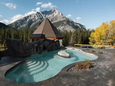 a pool with a gazebo and a mountain at Hotel Canoe and Suites in Banff