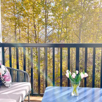 a vase of flowers on a table on a balcony at Immersed in the scenery of Canmore in Canmore
