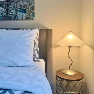 a lamp sitting on a table next to a bed at Immersed in the scenery of Canmore in Canmore