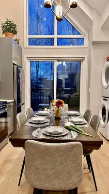 a dining room table with chairs and a large window at Immersed in the scenery of Canmore in Canmore