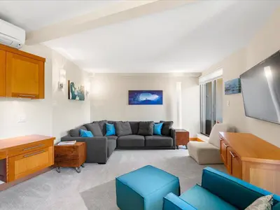 a living room with a couch and a flat screen tv at Ski In/Out, Steam Shower, Pool, Hot Tub, Sauna in Whistler