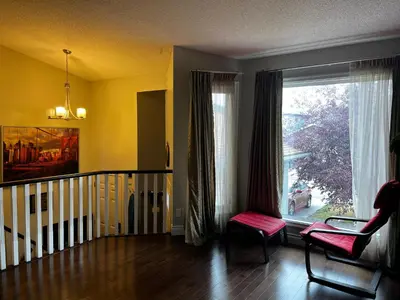 a living room with a window and a chair at citadel cozy quilt private bedroom in Calgary