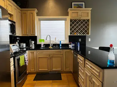 a kitchen with wooden cabinets and a sink at citadel cozy quilt private bedroom in Calgary