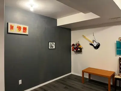 a living room with a gray wall and a table at hidden valley new basement suite with private bathroom! in Calgary