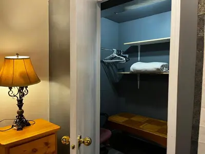a door leading into a room with a bed and a lamp at hidden valley new basement suite with private bathroom! in Calgary