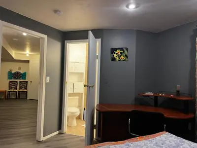 a bedroom with a bed and a desk and a toilet at hidden valley new basement suite with private bathroom! in Calgary