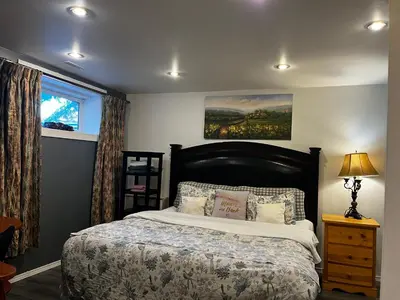 a bedroom with a large bed and a window at hidden valley new basement suite with private bathroom! in Calgary