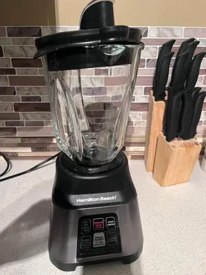 a blender sitting on top of a counter with knives at Cozy Walkout suite with King bed, Kitchen, Parking & Patio in Calgary