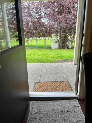 an open door with a view of a yard at Cozy Walkout suite with King bed, Kitchen, Parking & Patio in Calgary