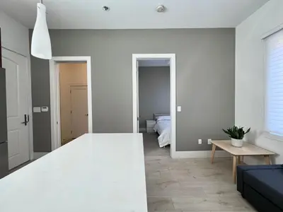a living room with white walls and a white table at Brand New Modern Laneway House in Vancouver