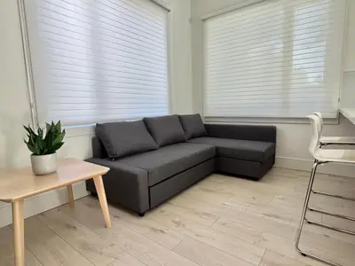 a living room with a couch and a table at Brand New Modern Laneway House in Vancouver