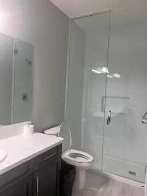 a bathroom with a toilet and a glass shower at Flowealth Property Luxury Villa Near Lake Netflix TV Wifi in Calgary