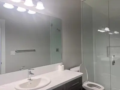 a bathroom with a toilet and a sink and a shower at Flowealth Property Luxury Villa Near Lake Netflix TV Wifi in Calgary
